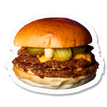 Smash burger composé d'un bun brioché beurré, un smashed patty de bœuf, american cheese, pickles cornichon, dés d’oignons, sauce KÜBE
